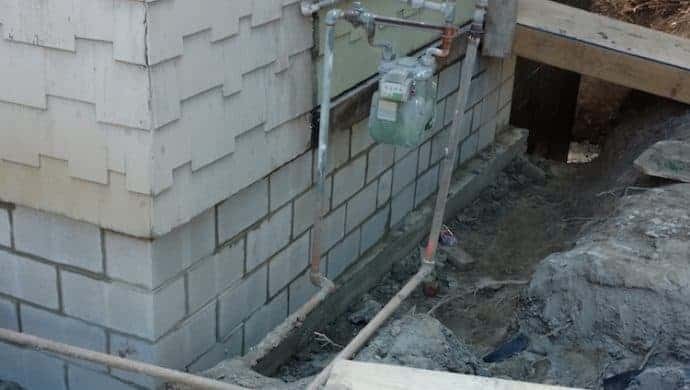 Foundation wall replacement with exposed block wall and utility lines